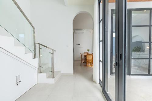 a hallway with glass doors and a dining room at Byjexa Villa by Betterplace in Uluwatu