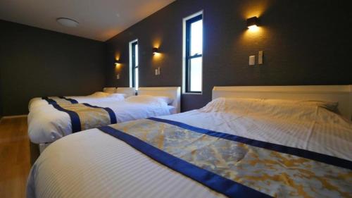 a bedroom with two beds and two windows at Padel Okinawa Villa - Vacation STAY 32469v in Uruma