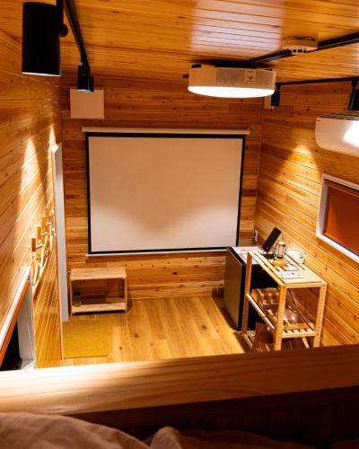 a projection screen in a room with wooden walls at CampBaseKadojin - Vacation STAY 33535v in Tenkawa
