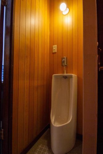 a urinal in a bathroom with wooden walls at Kodatel Hakodate Daimon - Vacation STAY 15893 in Shinkawachō
