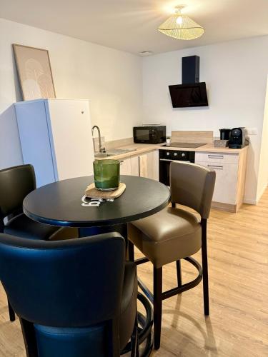 タン・レルミタージュにあるAppartement chaleureuxのテーブルと椅子のあるキッチンとキッチンのあるキッチン