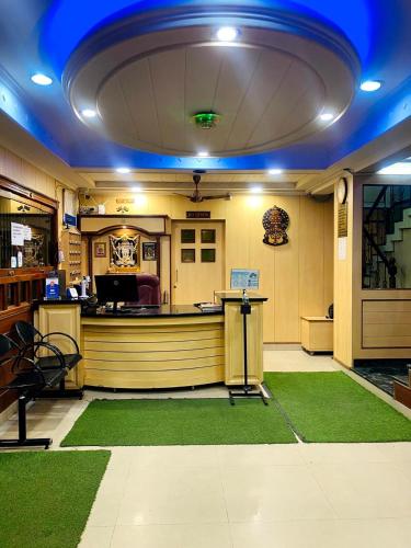 a waiting area with a green carpet in a salon at Mayur Paradise in Bangalore