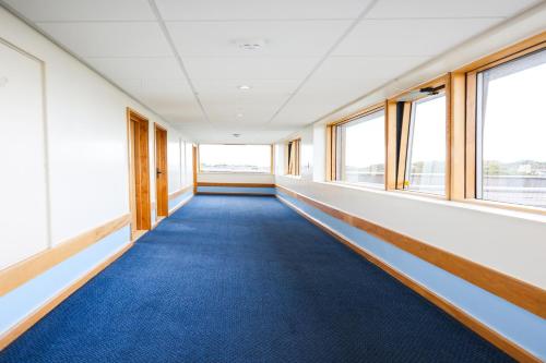 an empty room with blue carpet and windows at GO2 Lancaster Centre Hotel by OYO in Lancaster