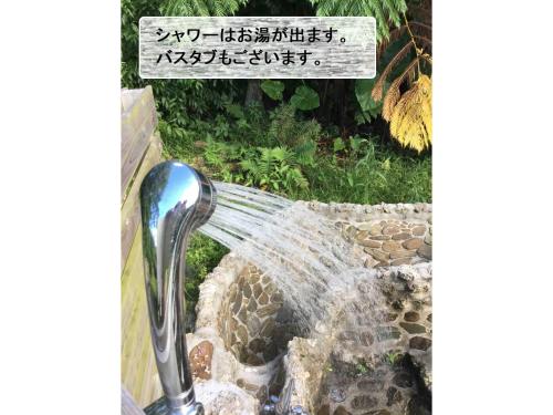 a water faucet in a fountain with a sign at Nature Lodge Niji no Mame - Vacation STAY 45236v in Fukai