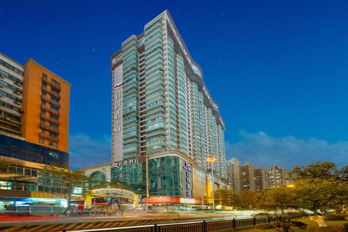 a tall glass building in a city at night at Yizhi Hotel - Guangzhou Shamian Island Huangsha Metro Station-Canton Fair free shuttle bus included Breakfast in Guangzhou