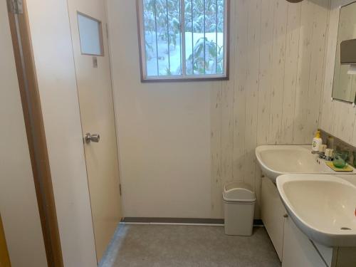 baño blanco con lavabo y ventana en MEGA Shakotan base - Vacation STAY 56583v, en Notsuka