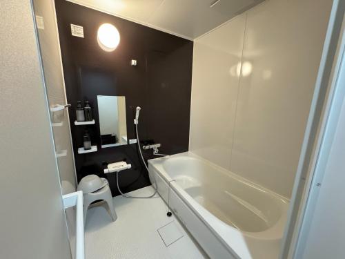 a bathroom with a white tub and a toilet at CalmbaseGARAGE - Vacation STAY 50325v in Izu