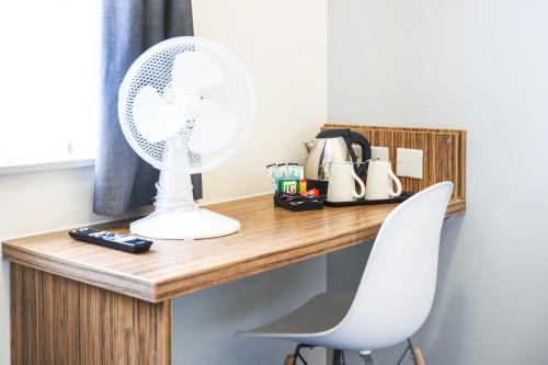 a white fan sitting on top of a wooden desk at GO2 Lancaster Centre Hotel by OYO in Lancaster