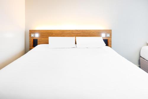 a bedroom with a large bed with two pillows at GO2 Lancaster Centre Hotel by OYO in Lancaster