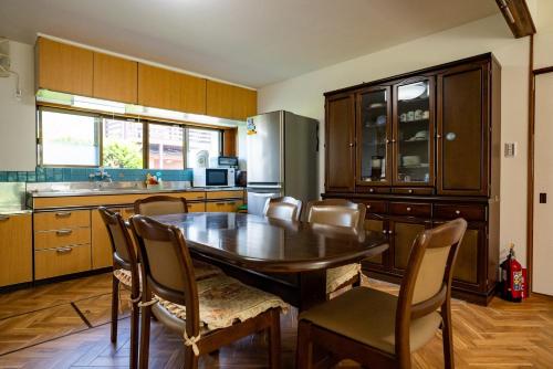 a kitchen with a table and chairs and a refrigerator at Hanareya Hyō - Vacation STAY 49547v in Nakatsugawa