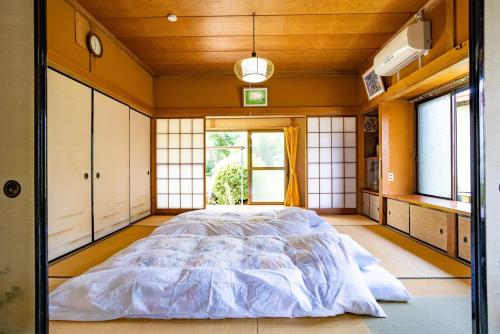 a large bed in a room with windows at Hanareya Hyō - Vacation STAY 49547v in Nakatsugawa