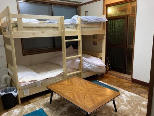 TakaikeにあるObachanchi - Vacation STAY 56999vのテーブル付きの部屋に二段ベッドが2つある