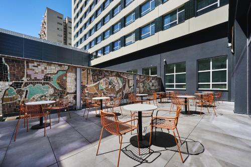 a patio with tables and chairs on a building at voco Katowice by IHG in Katowice