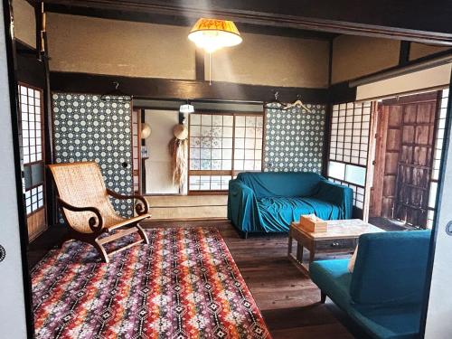 a living room with a couch and a chair and a table at Nano Village Okayama - Vacation STAY 66531v in Kaga