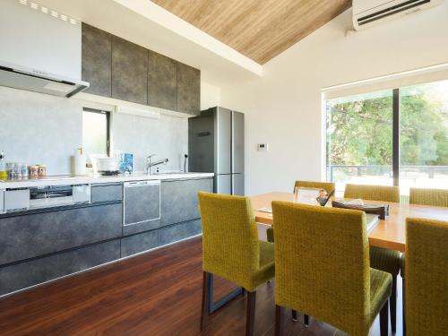 une cuisine et une salle à manger avec une table et des chaises en bois dans l'établissement T.Square, à Akashi