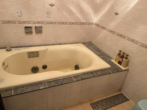 La salle de bains est pourvue d'une baignoire et de carrelage. dans l'établissement Sasebo - Cottage - Vacation STAY 56014v, à Sasebo