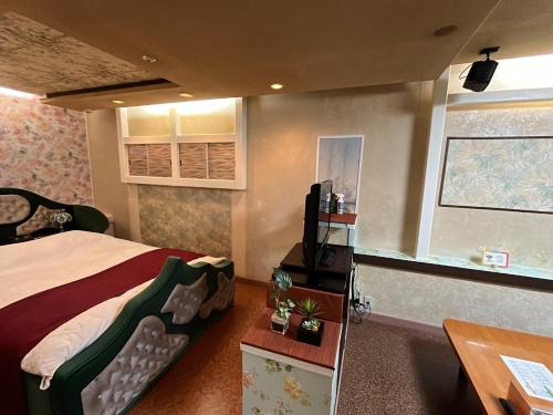 une chambre avec un lit, un bureau et une télévision dans l'établissement Sasebo - Cottage - Vacation STAY 56014v, à Sasebo