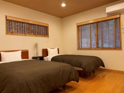 a bedroom with two beds and two windows at Rental Villa Karuizawa Honors Hill - Vacation STAY 71491v in Oiwake