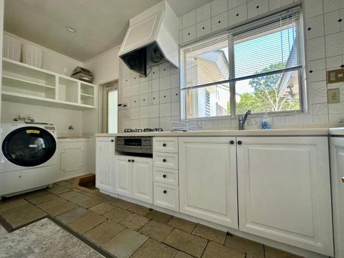 eine weiße Küche mit Spüle und Geschirrspüler in der Unterkunft Nasu Kogen Yamagoya - Vacation STAY 29353v in Shiozawa