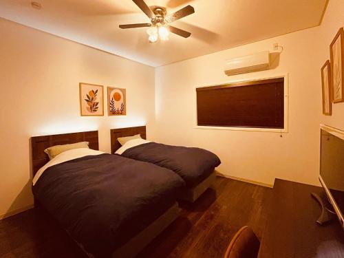 a bedroom with a bed and a ceiling fan at Second floor - Vacation STAY 16317 in Ginowan