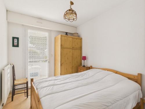 une chambre avec un lit, une chaise et une fenêtre dans l'établissement 400m de la Grande plage, 2 adultes 2 enfants, à Saint-Gilles-Croix-de-Vie