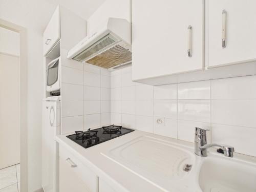 une cuisine blanche avec une cuisinière et un évier dans l'établissement 400m de la Grande plage, 2 adultes 2 enfants, à Saint-Gilles-Croix-de-Vie