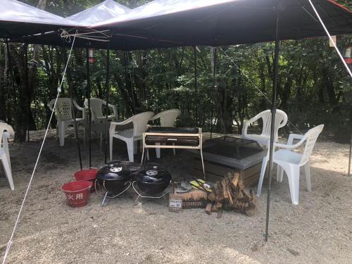 a tent with white chairs and a table and a grill at Nasu Highlands Mountain Hut - Vacation STAY 81757v in Shiozawa