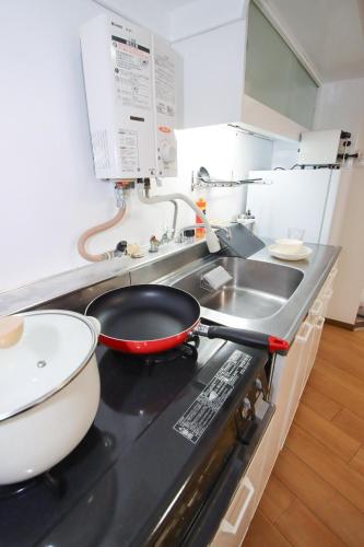 a kitchen with a frying pan on a stove at Kurokawa Building No, 201 - Vacation STAY 16198 in Nagoya
