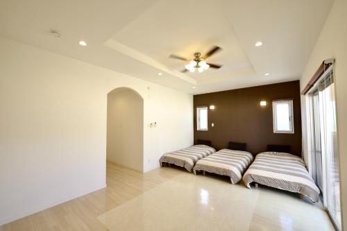 a row of beds in a room with a ceiling at Pleasant Stay - Vacation STAY 76420v in Uruma