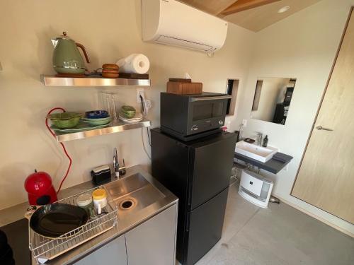 a small kitchen with a sink and a microwave at HUCKLEBERRY GARDEN - Vacation STAY 94899v in Kujukuri
