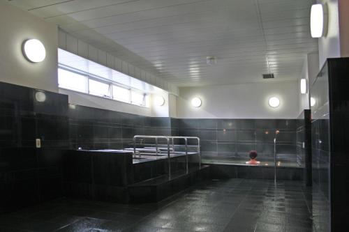 a person sitting in a bath tub in a bathroom at Utage HANARE - Vacation STAY 93680v in Kainan