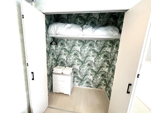a bedroom with a bunk bed in a room with palm trees wallpaper at Karatsu seaside house - Vacation STAY 94789v in Karatsu