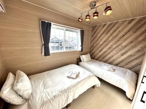 a bedroom with two beds and a window at Karatsu seaside house - Vacation STAY 94789v in Karatsu