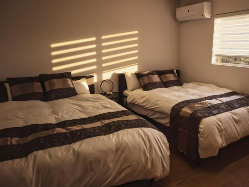 a bedroom with two beds and a window at Cliffside Villa NIRVANA - Vacation STAY 98988v in Yakushima