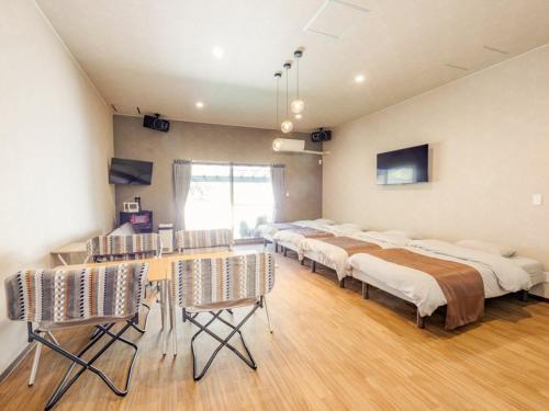 広島市にあるRiverside Glamping Kamiseno - Vacation STAY 92757vのベッド4台とテーブルと椅子のある部屋