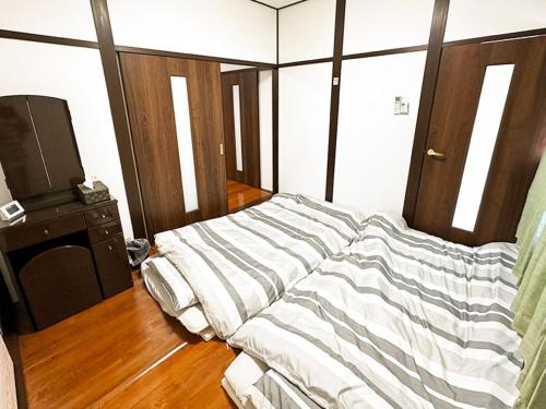 a bedroom with a large bed with striped sheets at Tanabe no Yado Ataigawa - Vacation STAY 10883v in Tanabe