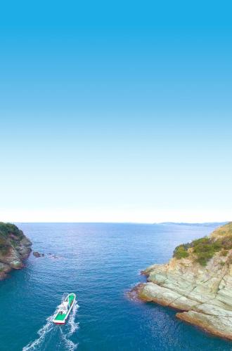 a boat in the water next to a cliff at HABi-Sekido5 - Vacation STAY 16276 in Wakayama