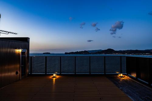 a balcony with a view of the ocean at night at The View Minamiboso - Vacation STAY 16265 in Minamiboso