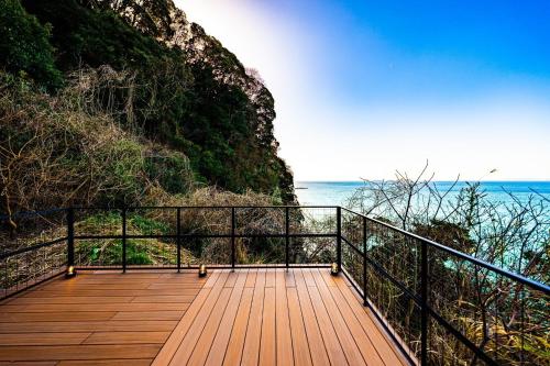 a wooden walkway leading down to the ocean on a cliff at The View Minamiboso - Vacation STAY 16265 in Minamiboso