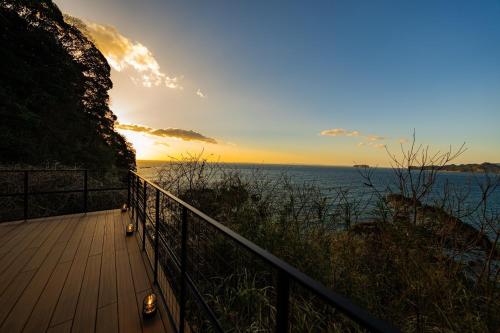 a sunset over the ocean with a wooden boardwalk at The View Minamiboso - Vacation STAY 16265 in Minamiboso