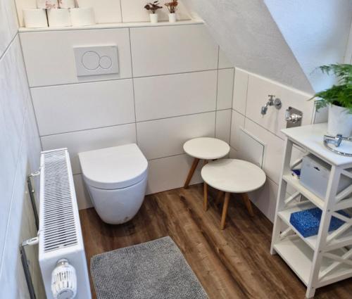 a small bathroom with a toilet and two stools at MAIN Quartier in Kitzingen