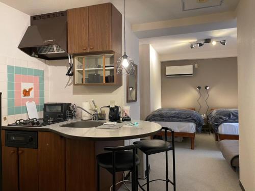 a kitchen with a sink and a room with a bed at Few Days Condominium Jozankei Room 302 - Vacation STAY 16313 in Jozankei