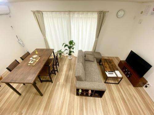 a living room with a couch and a dining table at Shonan Katase HOME - Vacation STAY 12525v in Fujisawa