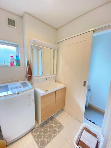 a small bathroom with a sink and a refrigerator at Shonan Katase HOME - Vacation STAY 12525v in Fujisawa