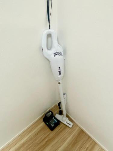 a white hair dryer hanging on the corner of a wall at Shonan Katase HOME - Vacation STAY 12525v in Fujisawa