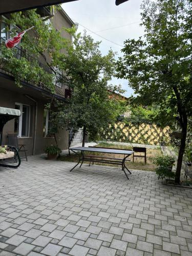 a picnic bench sitting on a brick patio at Charming Private House Pekini av in Tbilisi City