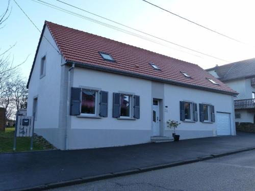 a white house with a red roof on a street at Spacious Stay in Lemberg in Lemberg