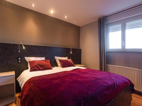 a bedroom with a large bed with a red blanket at Spacious Stay in Lemberg in Lemberg