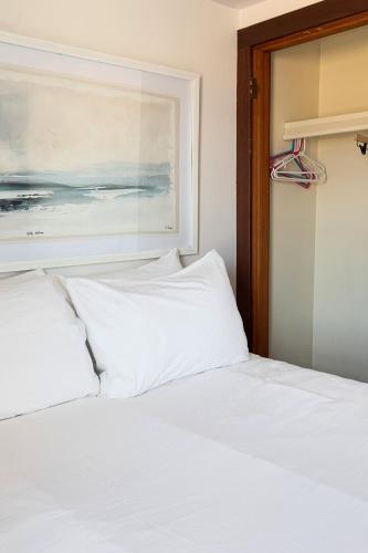a bed with white sheets and a painting on the wall at Lucky 7 at Lakeshore Resort in Traverse City