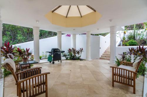 a large porch with chairs and a chandelier at Sadewa Villa in Port Elizabeth